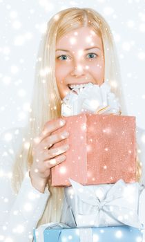 Happy woman holding Christmas gifts, silver background and snow glitter with copyspace, shopping and holidays