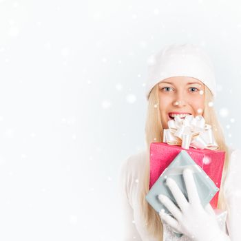 Happy woman holding Christmas gifts, silver background and snow glitter with copyspace, shopping and holidays