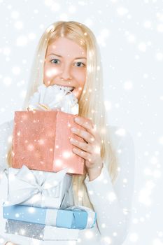 Happy woman holding Christmas gifts, silver background and snow glitter with copyspace, shopping and holidays