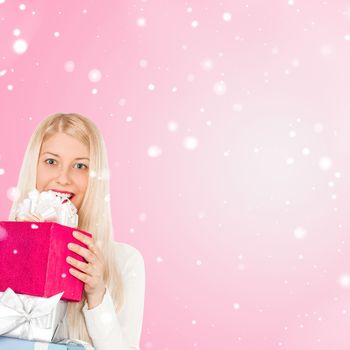 Happy woman holding Christmas gifts, pink background and snow glitter with copyspace, shopping and holidays