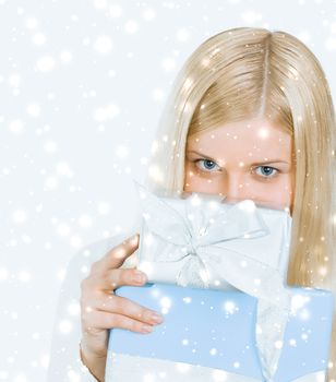 Happy woman holding Christmas gifts, silver background and snow glitter with copyspace, shopping and holidays