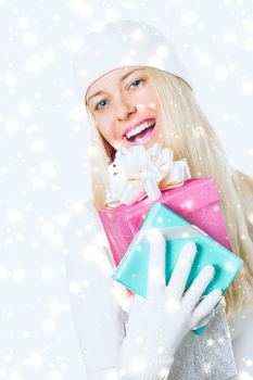 Happy woman holding Christmas gifts, silver background and snow glitter with copyspace, shopping and holidays