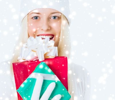 Happy woman holding Christmas gifts, silver background and snow glitter with copyspace, shopping and holidays