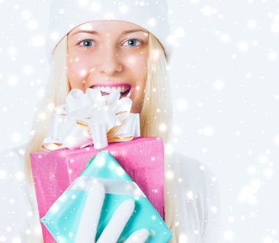 Happy woman holding Christmas gifts, silver background and snow glitter with copyspace, shopping and holidays