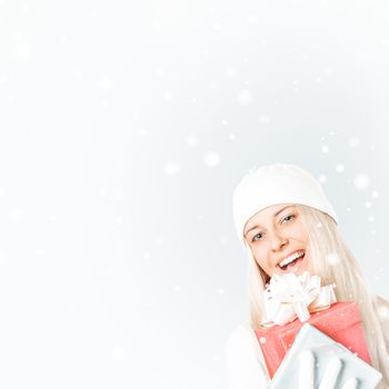 Happy woman holding Christmas gifts, silver background and snow glitter with copyspace, shopping and holidays