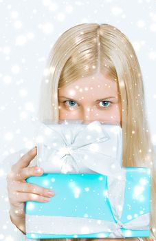 Happy woman holding Christmas gifts, silver background and snow glitter with copyspace, shopping and holidays