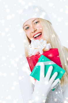 Happy woman holding Christmas gifts, silver background and snow glitter with copyspace, shopping and holidays