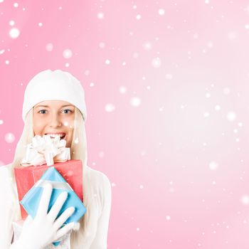 Happy woman holding Christmas gifts, pink background and snow glitter with copyspace, shopping and holidays