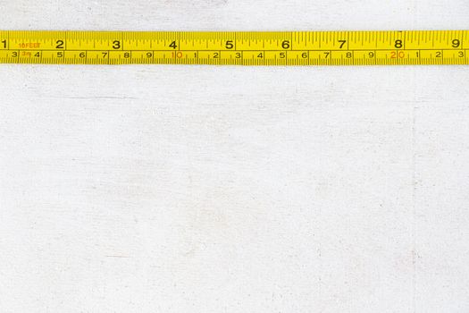 Metal ruler, centimeters and millimeters on the yellow ruler. Sizes on the white background