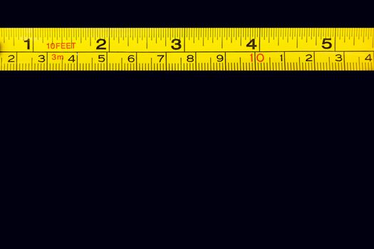 Tape measure centimeters and millimeters on the yellow ruler. Sizes and numbers on the black board