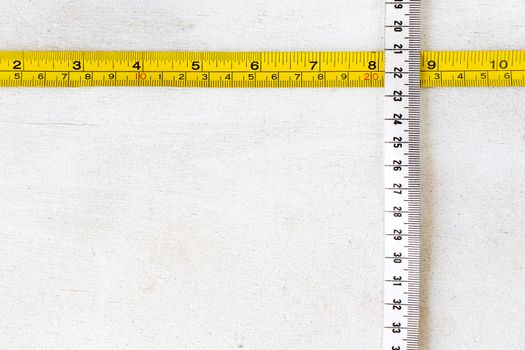 Metal ruler and Tape measure, centimeters and millimeters on the yellow ruler. Sizes on the white background