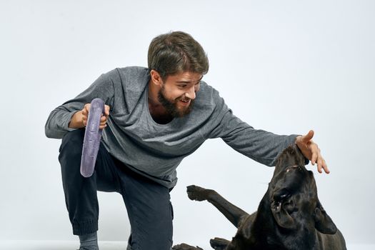 Man with dog training gray ring doing exercises pets light background. High quality photo