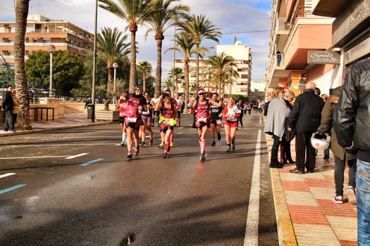 Santa Pola, Spain- January 20, 2019: Runners in the Half Marathon of the fishing village of Santa Pola, province of Alicante, on a sunny day in January
