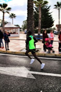 Santa Pola, Spain- January 20, 2019: Runners in the Half Marathon of the fishing village of Santa Pola, province of Alicante, on a sunny day in January