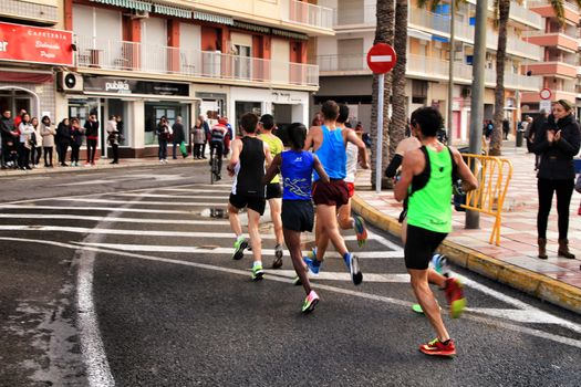Santa Pola, Spain- January 20, 2019: Runners in the Half Marathon of the fishing village of Santa Pola, province of Alicante, on a sunny day in January
