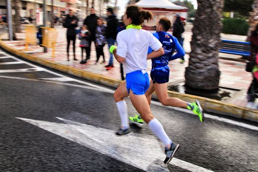 Santa Pola, Spain- January 20, 2019: Runners in the Half Marathon of the fishing village of Santa Pola, province of Alicante, on a sunny day in January
