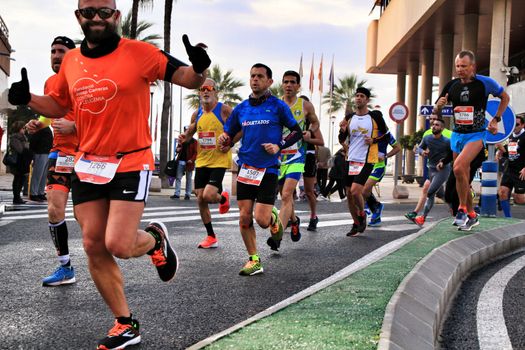 Santa Pola, Spain- January 20, 2019: Runners in the Half Marathon of the fishing village of Santa Pola, province of Alicante, on a sunny day in January
