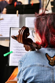 Elche, Alicante- October 20, 2019: Young girl playing the cello in an orchestra on the street in Elche for the fight of breast cancer