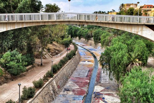 Elche, Alicante, Spain- September 12, 2018: Beautiful and Lush landscape of the Vinalopo riverbed in Elche, Alicante. People walking between vegetation.