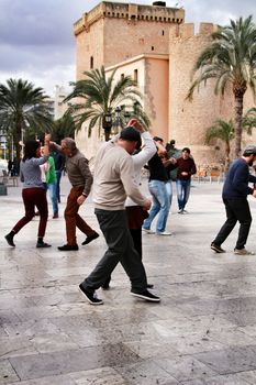 Elche, Alicante, Spain- February 19, 2019: People enjoying and dancing swing in the street in winter