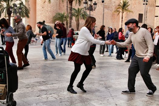 Elche, Alicante, Spain- February 19, 2019: People enjoying and dancing swing in the street in winter