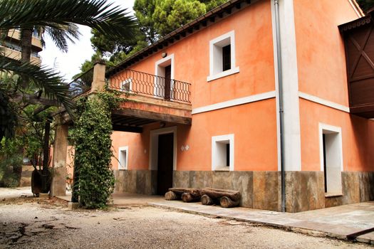 Elche, Spain- 30 August, 2020: Typical and colorful house in a palm orchard in Elche, Spain on a sunny day. Huerto de San Placido.