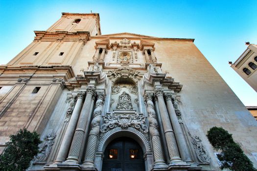 Elche, Alicante, Spain- September 9, 2020: Main entrance and beautiful Valencian baroque facade of Santa Maria church dedicated to the Lady of the Assumption