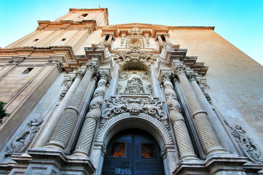 Elche, Alicante, Spain- September 9, 2020: Main entrance and beautiful Valencian baroque facade of Santa Maria church dedicated to the Lady of the Assumption