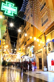 Elche, Alicante, Spain- December 11, 2019: People enjoying and walking at night through the beautiful streets of Elche decorated with lighting and Christmas motifs