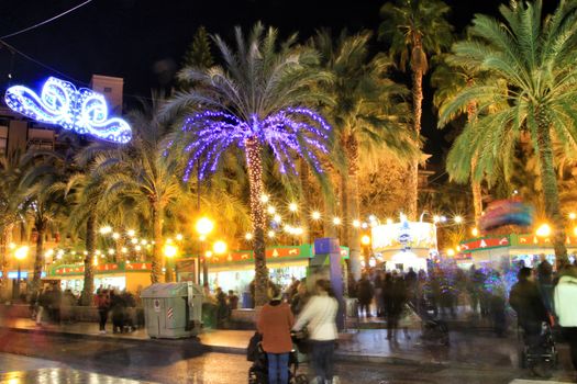 Elche, Alicante, Spain- December 11, 2019: People enjoying and walking at night through the beautiful streets of Elche decorated with lighting and Christmas motifs