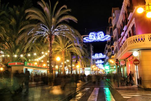 Elche, Alicante, Spain- December 11, 2019: People enjoying and walking at night through the beautiful streets of Elche decorated with lighting and Christmas motifs