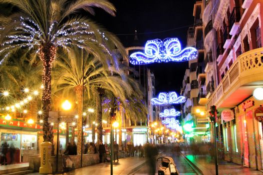 Elche, Alicante, Spain- December 11, 2019: People enjoying and walking at night through the beautiful streets of Elche decorated with lighting and Christmas motifs
