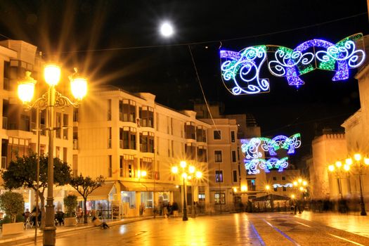 Elche, Alicante, Spain- December 11, 2019: People enjoying and walking at night through the beautiful streets of Elche decorated with lighting and Christmas motifs