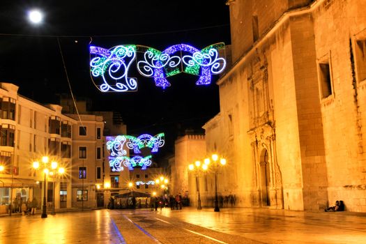 Elche, Alicante, Spain- December 11, 2019: People enjoying and walking at night through the beautiful streets of Elche decorated with lighting and Christmas motifs