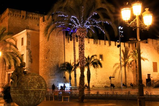 Elche, Alicante, Spain- December 11, 2019: People enjoying and walking at night through the beautiful streets of Elche decorated with lighting and Christmas motifs
