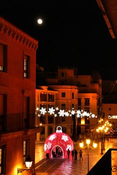 Elche, Alicante, Spain- December 11, 2019: People enjoying and walking at night through the beautiful streets of Elche decorated with lighting and Christmas motifs