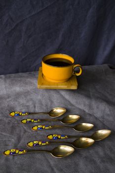 Vintage spoons, silverware and black coffee cup