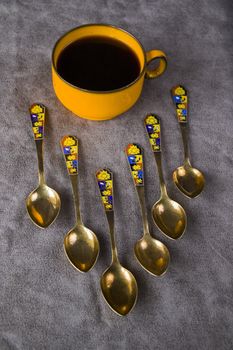 Vintage spoons, silverware and black coffee cup