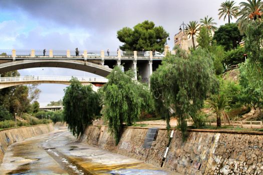 Elche, Alicante, Spain- November 16, 2018 - Landscape of the hillside of the Vinalopo River in Elche with its bridges and green vegetation after a rainy day of Autumn