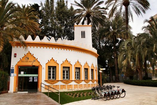 Elche, Alicante, Spain- February 19, 2019: Tourist Office surrounded by palm trees in the municipal park of Elche, Alicante province, Spain