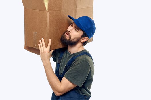 A man in a working uniform with a box in his hands delivery transportation work. High quality photo