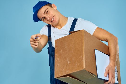 Man worker with cardboard box delivery loader lifestyle blue background. High quality photo