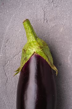 Fresh ripe eggplant on stone concrete background, top view macro