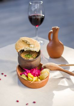 Georgian traditional food Lobio or kidney and haricot beans soup with picked vegetables and red wine. Tbilisi, Georgia.