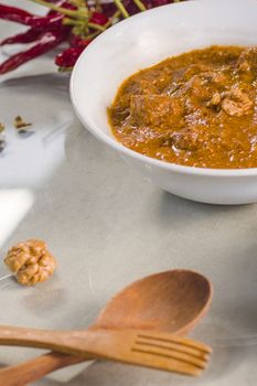 Georgian traditional food soup Kharcho or walnuts souse with beef meal, dry red pepper, tomatoes and other ingredients. Withe wine and wooden spoon. Tbilisi, Georgia.