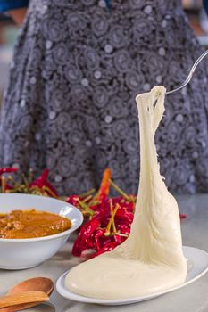 Georgian traditional food Elarji or cornflour with cheese and soup Kharcho or walnuts souse with meat, dry red pepper and tomatoes.Wooden spoon and folk on the table.