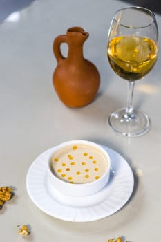 Walnut sauce in the bowl on the table with white wine and walnuts, ready to eat.