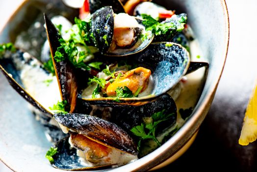 Cooked Blue mussels in clay dish with lemon