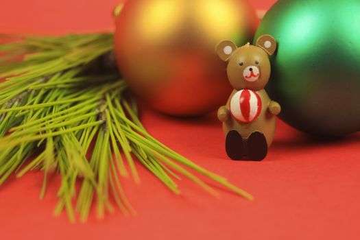 Wooden teddy bear with Christmas decoration on red background