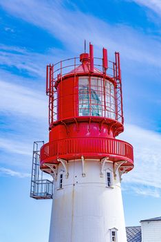 Historic red white lighthouse on the edge of rocky sea coast,  Lindesnes, South Norway